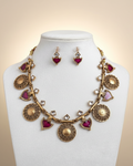 Elegant antique gold necklace with vibrant magenta drops